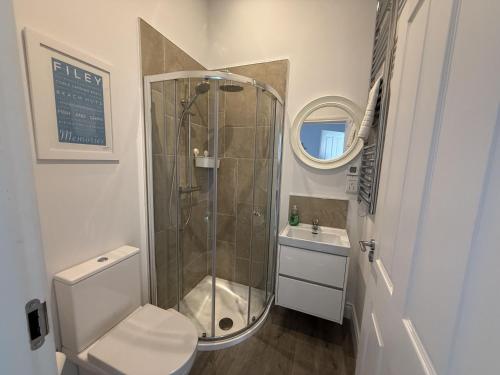 a bathroom with a shower and a toilet and a sink at The Lake House, The Bay Filey, sleeps 4 in 2 double rooms with ensuites, 1 dog welcome in Filey
