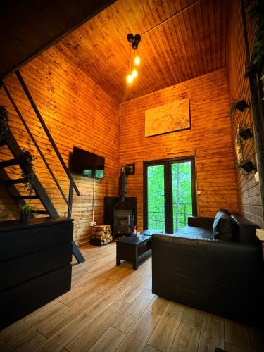 a living room with a couch and a fireplace at M Cabin Tree house Predeal Ciubar in Predeal