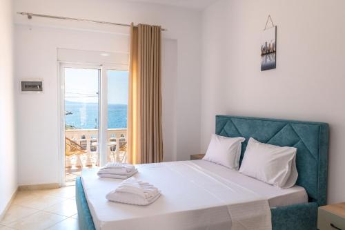 a bedroom with a large white bed with a balcony at The Hidden Sea Rooms in Sarandë