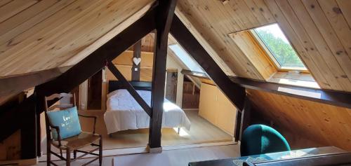 a small attic room with a bed and a window at La maison de Fée-Licité in Salignac Eyvigues