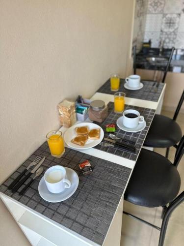 a table with cups of coffee and plates of food at Hotel Don Luis in Paso de los Libres