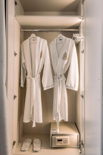 a closet with white robes and a microwave at Royal Nidri Suites in Nydri
