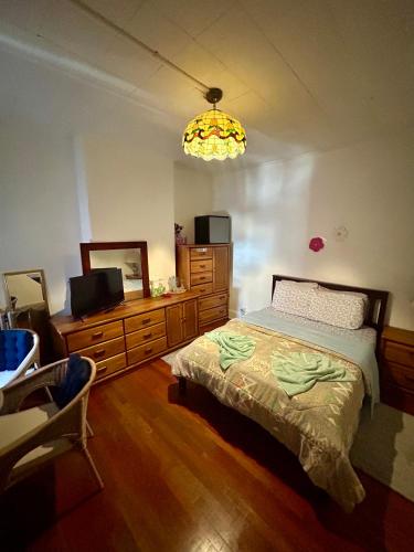 a bedroom with a bed and a television and a chandelier at Las margaritas in Allentown
