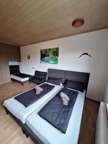 a bedroom with a large bed and a couch at Pension Haus Marianne in Bad Vöslau