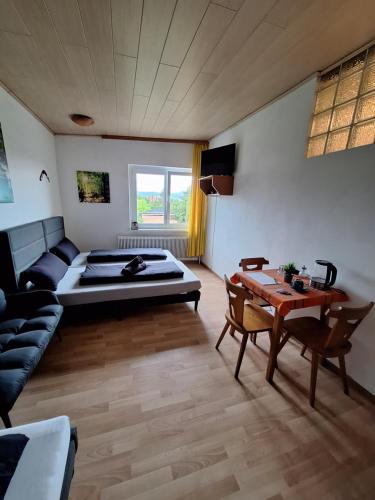 a room with a bed and a table and a couch at Pension Haus Marianne in Bad Vöslau
