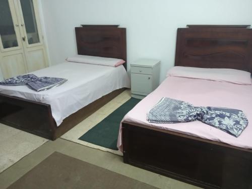 a bedroom with two beds with ties on them at لؤلؤه الفيروز in Marsa Matruh