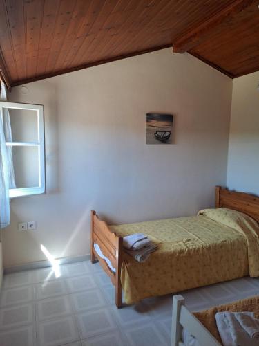 a bedroom with a bed and a window at Retire Alefkimmon in Lefkimmi