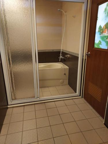 a bathroom with a shower and a bath tub at Hong Wa Cuo南投埔里紅瓦厝山居民宿森林系住宿生態手作體驗 in Puli