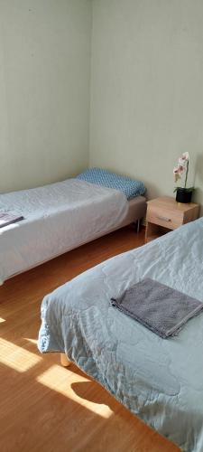 a bedroom with two beds and a wooden floor at Eina house near the E4 road in Eina