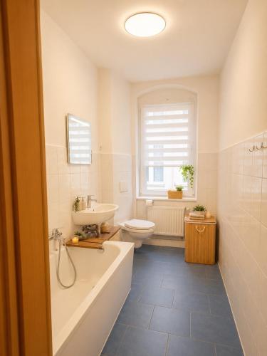 a bathroom with a tub and a toilet and a sink at Pension J&M in Meißen
