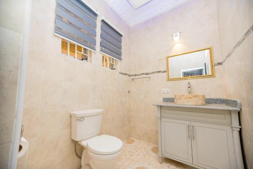 a bathroom with a toilet and a sink and a mirror at XTENDED STAY Gh in Accra