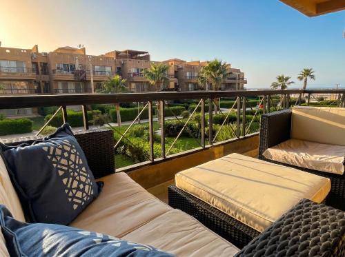 a balcony with wicker furniture and a view of buildings at 396 Blumar Chalet North Coast Sidi-abdelrahman families & couples only in El Alamein
