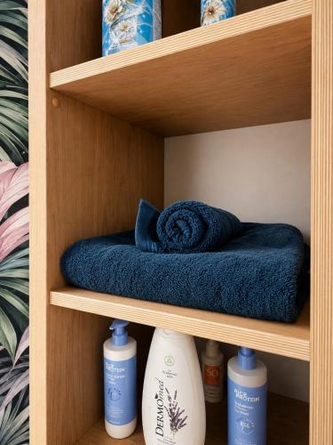 a wooden shelf with bottles ofodorizers and a blue towel at No 7 Plasmolen in Middelaar