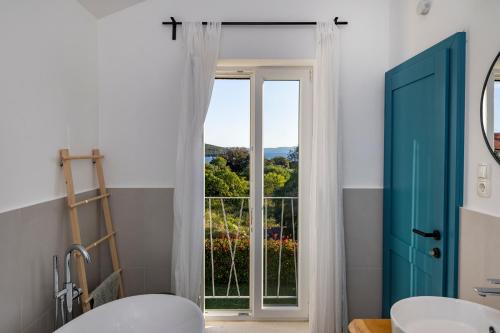 a bathroom with a blue door and a window at Villa Vela Muline - 8 plus 2 guests - heated pool in Ugljan