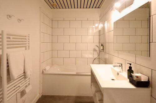 a bathroom with a tub and a sink and a bath tub at Hotel du Pot d'Etain in Chalons en Champagne