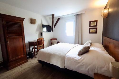 a bedroom with a bed and a window and a desk at Hotel du Pot d'Etain in Chalons en Champagne