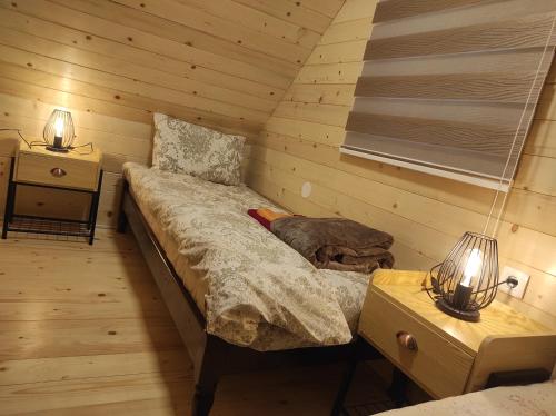 a room with a bed in a log cabin at Apartmani Slavko in Konjska Reka