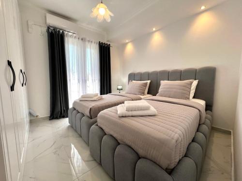 two beds in a bedroom with a large bed frame at Villa Joel in Kefallonia