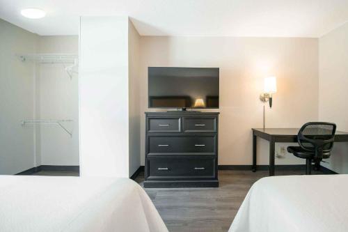 a bedroom with a desk and a dresser with a television at Extended Stay America Suites - Columbia - Columbia Corporate Park in Columbia