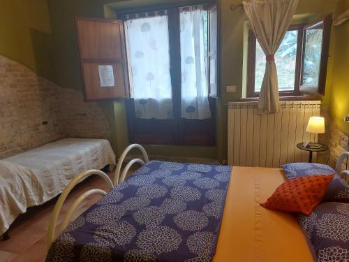 a room with two beds and a table and a window at B&B Cà Giovanni Country Resort Pet Friendly in Urbino