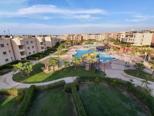 an aerial view of a resort with two pools at Chalet with roof pool view in Dawwār ‘Abd Allāh