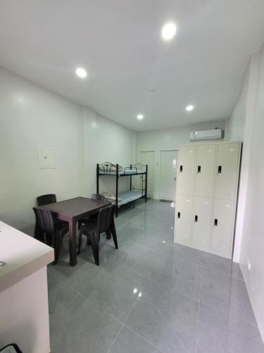 a room with a table and a bunk bed at MAOS Building in Batangas City