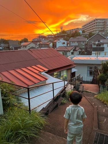 a young child walking down a stairs in front of a house at yadobankkukomae19 in Fukuoka