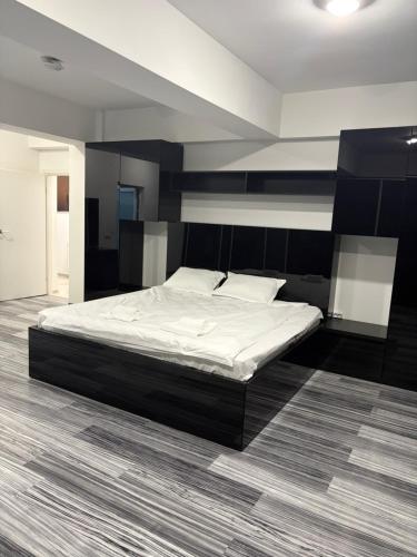 a bedroom with a large bed with a black headboard at Rania Penthouse 1 in Şelimbăr