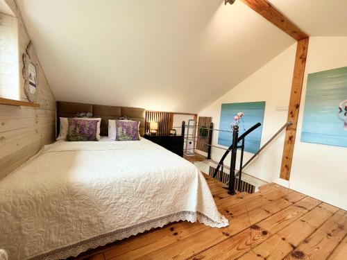 a bedroom with a large bed in a attic at Domek Lawenda z Ogrodem, konsolą PS4 z grami, Netflixem i Bezpłatnym Parkingiem in Szczecin