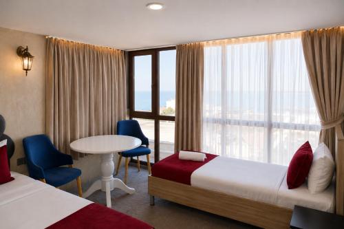 a hotel room with two beds and a table and a window at Old Town Hotel in Baku