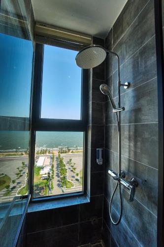a bathroom with a shower with a large window at The Pathway Condotel in Sầm Sơn