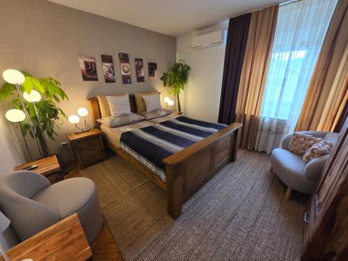 a bedroom with a bed and a couch and a chair at Apartment Andy in Medvode