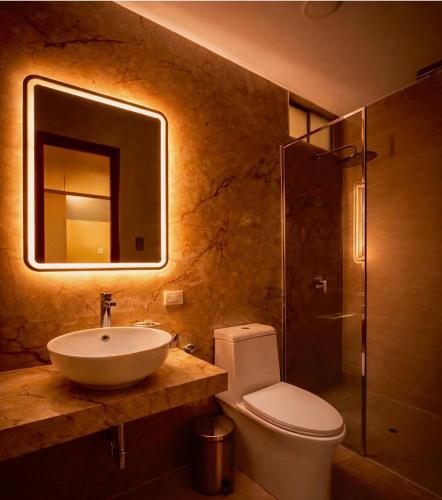 a bathroom with a sink and a toilet and a shower at Centrica Suite Hotel in Huarmey