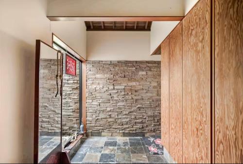 a room with a brick wall and a doorway at Kasumi-an in Kumamoto