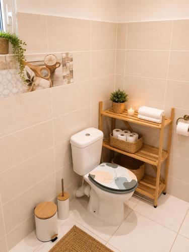 a bathroom with a toilet and a shelf with towels at Kaz an Fanmi in Les Abymes