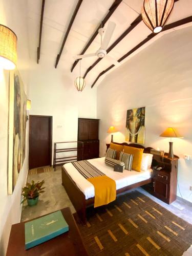 a bedroom with a bed and a table in it at Plantation Villa in Kalutara