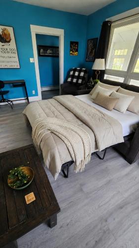 a large bed in a bedroom with a blue wall at Cozy One Bedoom apartment in Saint John