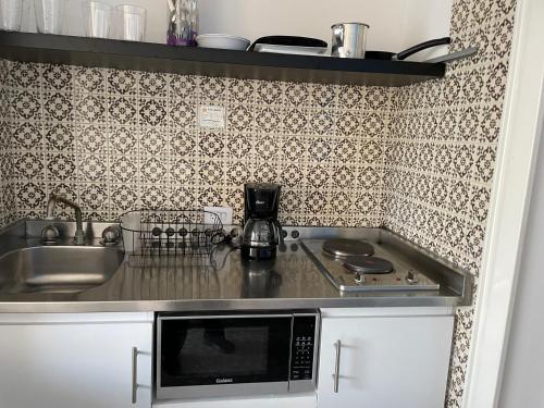 a kitchen with a sink and a microwave at Bonita Suite Torres Gemelas in Acapulco