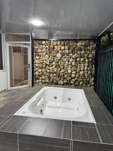 a bath tub in a room with a stone wall at El Chaparral in Yopal