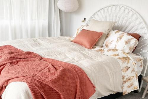 a white bed with a red blanket on it at Herea Bunker in Turangi