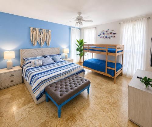 a bedroom with a bed and a blue wall at Beachfront Luxury Condo PGA Ocean View 4BR in Boca del Soco