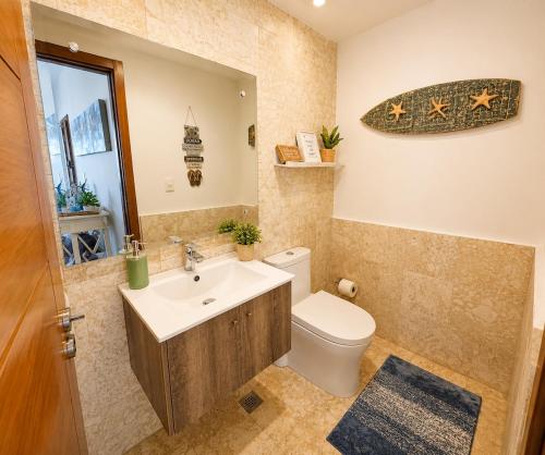 a bathroom with a toilet and a sink and a mirror at Beachfront Luxury Condo PGA Ocean View 4BR in Boca del Soco