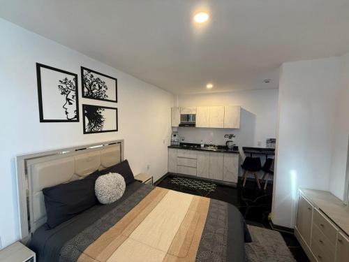 a bedroom with a large bed and a kitchen at Apartamento Maywood in Zacatecas