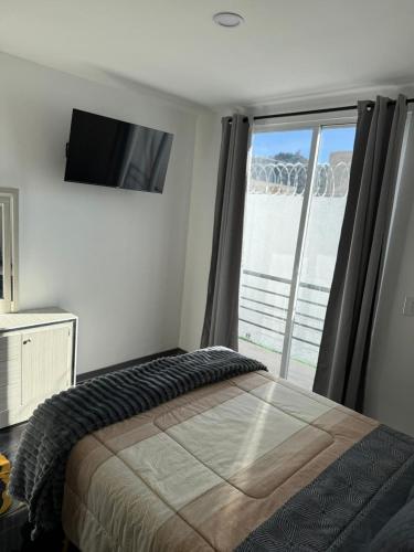 a bedroom with a bed and a large window at Apartamento Maywood in Zacatecas