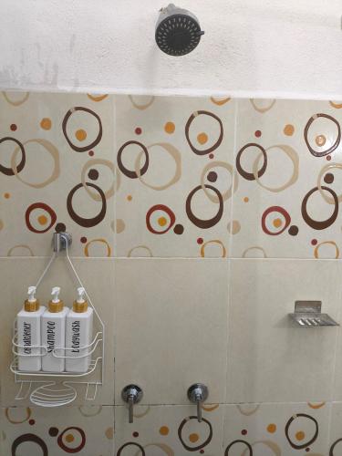 a bathroom with three shampoo bottles on a wall at Paraiso Suite Centrico con entrada independiente in Paraíso