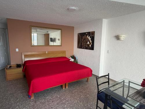 a bedroom with a red bed and a mirror at Bonita Suite Torres Gemelas in Acapulco