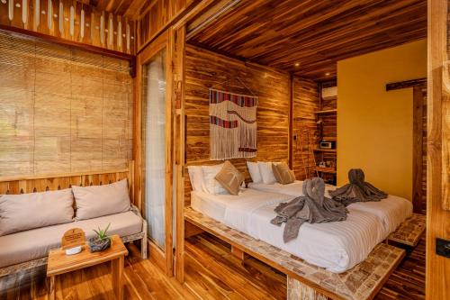 two beds in a room with wooden walls at Divine Divers Gili Meno in Gili Meno