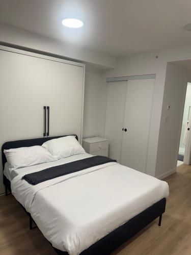 a bedroom with a large bed with white sheets at Executive suit in Surrey