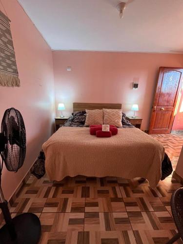 a bedroom with a bed with two lamps and a fan at Hostal el hermanito in San Pedro de Atacama