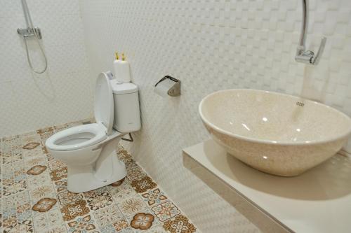 a bathroom with a toilet and a sink at The Tamarin Villas in Nusa Penida